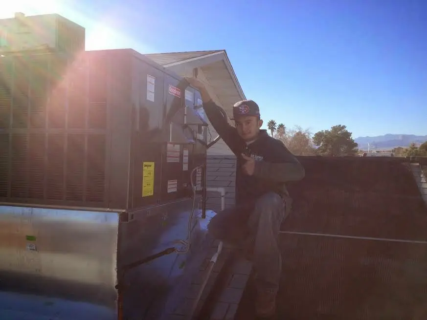 HVAC technician performing AC Tune-Up on a rooftop unit in Dalton